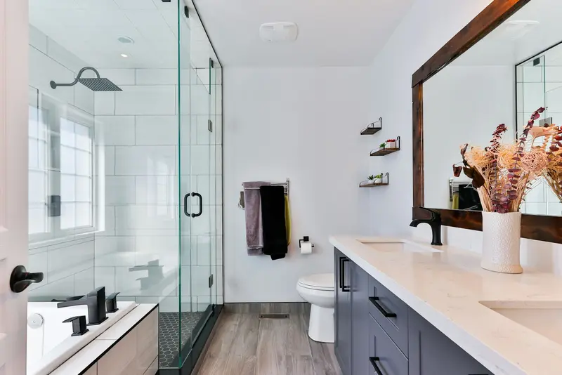 Baño con ducha de vidrio y doble bacha